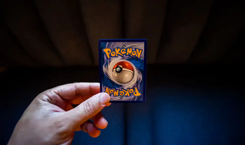 Staff member carefully sorting trading cards on a playmat